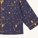 A close up of the Little Green Radicals classic pyjama top from the dark night classic set. showing the pocket and yellow trim detail around the wrist cuff and down the middle of the navy organic cotton top 