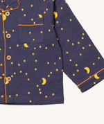 A close up of the Little Green Radicals classic pyjama top from the dark night classic set. showing the pocket and yellow trim detail around the wrist cuff and down the middle of the navy organic cotton top 