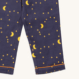 A close up of the Little Green Radicals classic pyjama bottoms from the dark night classic set. Showing the yellow trim around the bottom of the legs and a close up of the starry night print on navy organic cotton fabric.