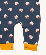 A close up of the Little Green Radicals everyday dungarees in sheep showing the popper fastener detail around the crotch and yellow trim detail on the leg cuff on navy organic cotton fabric.