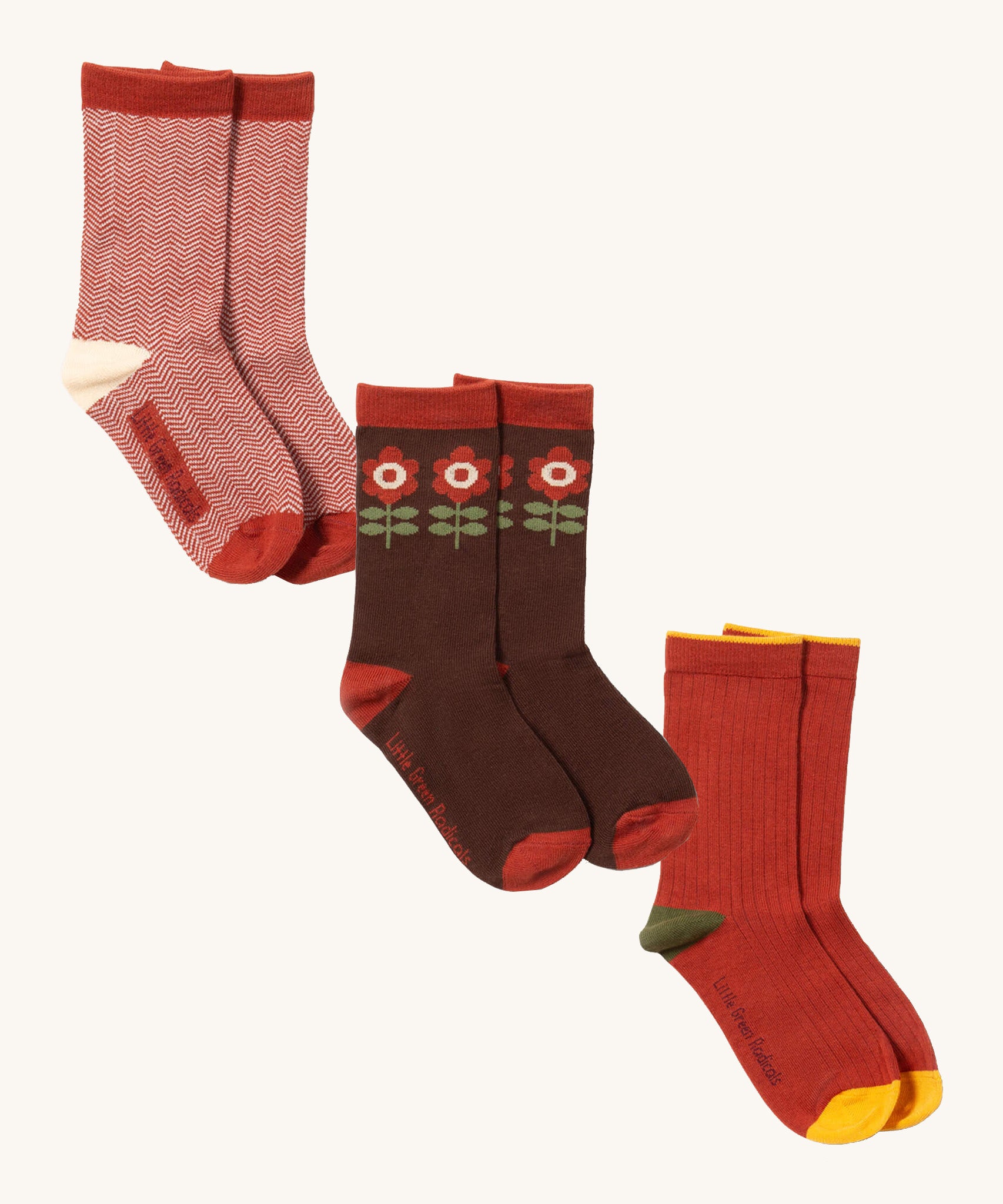 Little Green Radicals flowers ankle sock multipack set available at Babipur. A set of 3 GOTS organic cotton ankle socks including a red and white stripe sock, a brown sock with retro flowers and a red sock.