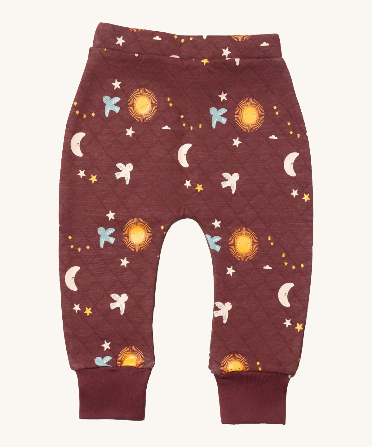 Little Green Radicals flying birds quilted joggers available at Babipur. A dark maroon GOTS organic cotton joggers with a quilted stitch with elasticated cuffs and cute prints of birds flying through a starry night