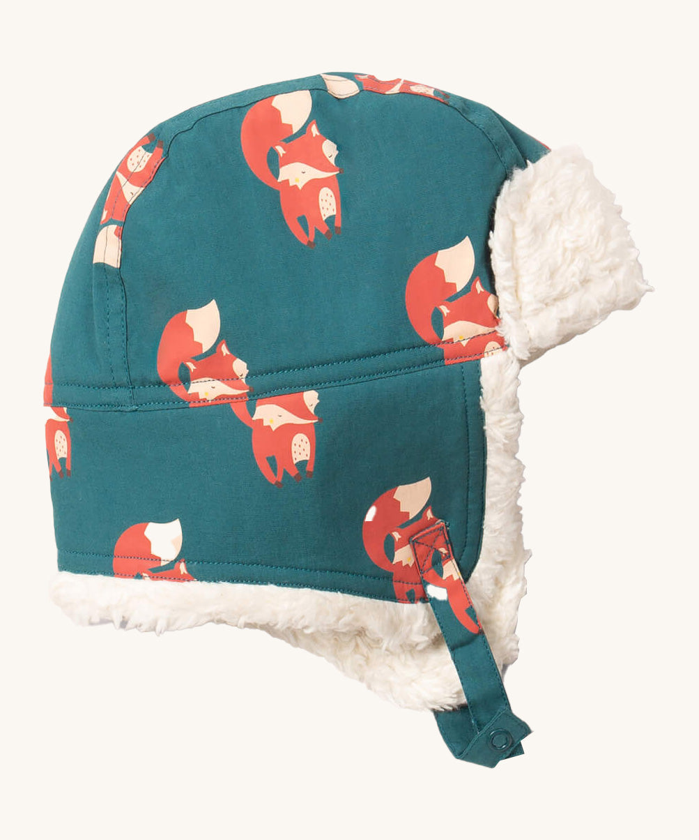 Little Green Radials sherpa fleece cosy hat in foxes. A GOTS organic cotton turquoise hat with turn up ear flaps and a white sherpa style fleece inner. Features a chin strap with popper fastener for a secure fit