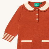 A close up of the Little Green Radicals ginger knitted collar dress. showing the cream collar and button fastener detail on dark orange organic cotton fabric