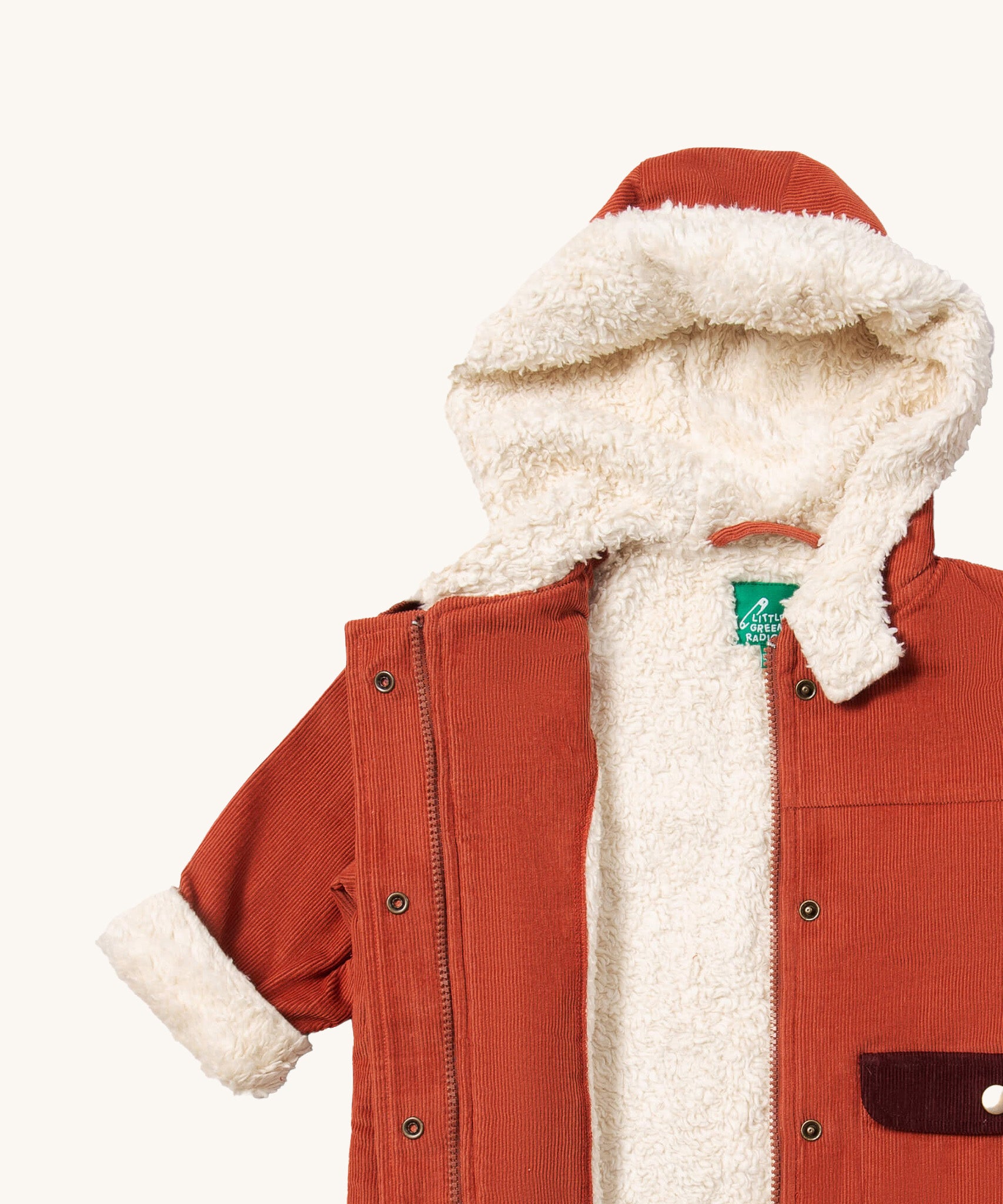 Little Green Radicals ginger sherpa toasty coat available at  Babipur. A GOTS organic cotton winter corduroy style jacket  in dark orange with a white fleece inner for warmth. Features a full length zip and popper fasteners for a secure fit.
