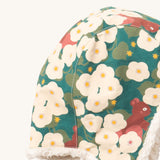 A close up of the Little Green Radials sherpa lined cosy hat in hedghore. Showing the cute squirrel and flower print and stitching detail on turquoise organic cotton fabric