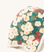 A close up of the Little Green Radials sherpa lined cosy hat in hedghore. Showing the cute squirrel and flower print and stitching detail on turquoise organic cotton fabric