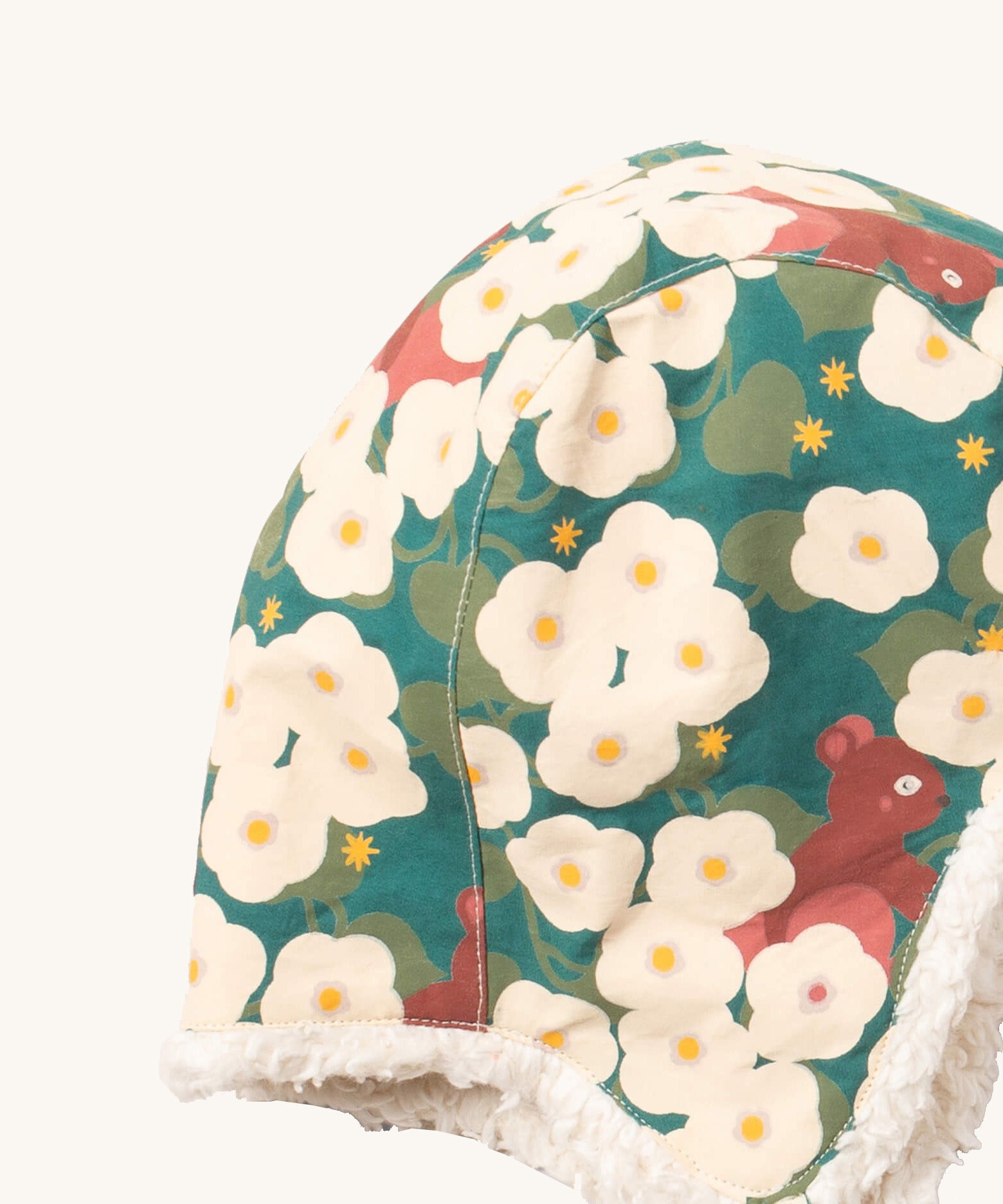 A close up of the Little Green Radials sherpa lined cosy hat in hedghore. Showing the cute squirrel and flower print and stitching detail on turquoise organic cotton fabric
