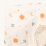 A close up of the sun and moon Little Green Radicals hooded blanket. Showing the cute sun and moon print detail and the white sherpa fleece detail on matching white organic cotton fabric.