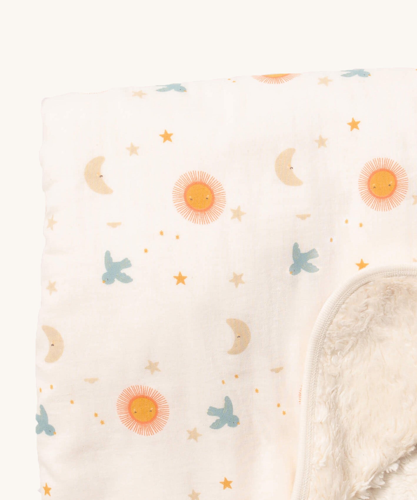 A close up of the sun and moon Little Green Radicals hooded blanket. Showing the cute sun and moon print detail and the white sherpa fleece detail on matching white organic cotton fabric.