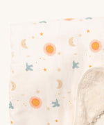 A close up of the sun and moon Little Green Radicals hooded blanket. Showing the cute sun and moon print detail and the white sherpa fleece detail on matching white organic cotton fabric.