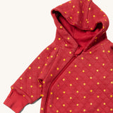 A close up of the Little Green Radicals hooded snug suit in red stars showing the hood and zip detail on GOTS organic cotton fabric
