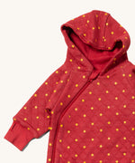 A close up of the Little Green Radicals hooded snug suit in red stars showing the hood and zip detail on GOTS organic cotton fabric