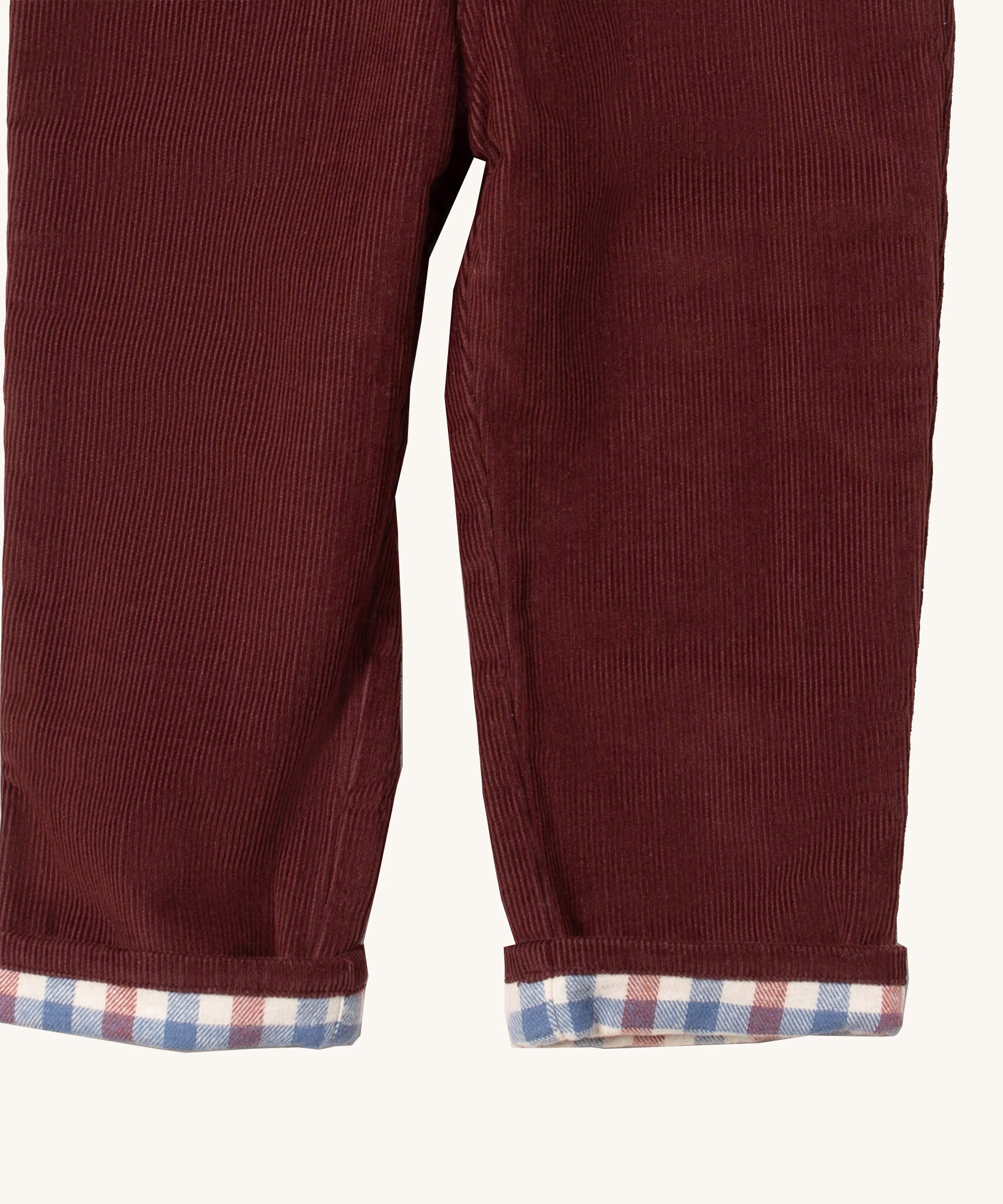 A close up of the Little Green Radicals jeans in chocolate corduroy. Showing the corduroy detail  and check design inner on dark maroon organic cotton fabric