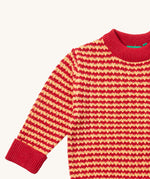 A close up of the Little Green Radicals snuggly knitted jumper in juniper stripe. Showing the yellow and pale red stripe knit detail and the matching pale red collar and turned up cuff