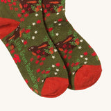 A close up of the Little Green Radicals winter rabbit ankle socks. Showing the rabbit design detail and red trim with the brand name on the the sole on dark green organic cotton fabric.
