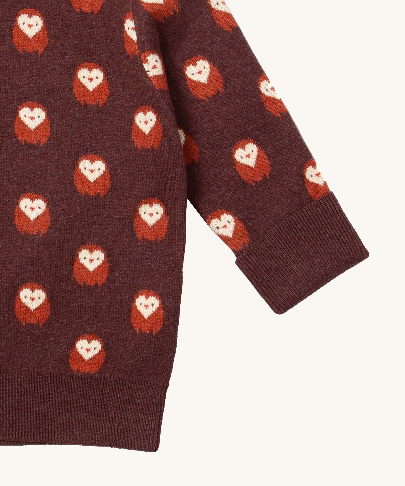 A close up of the  Little Green Radicals brown owl knitted jumper available at Babipur. Showing the cuff and hem detail on brown organic cotton fabric