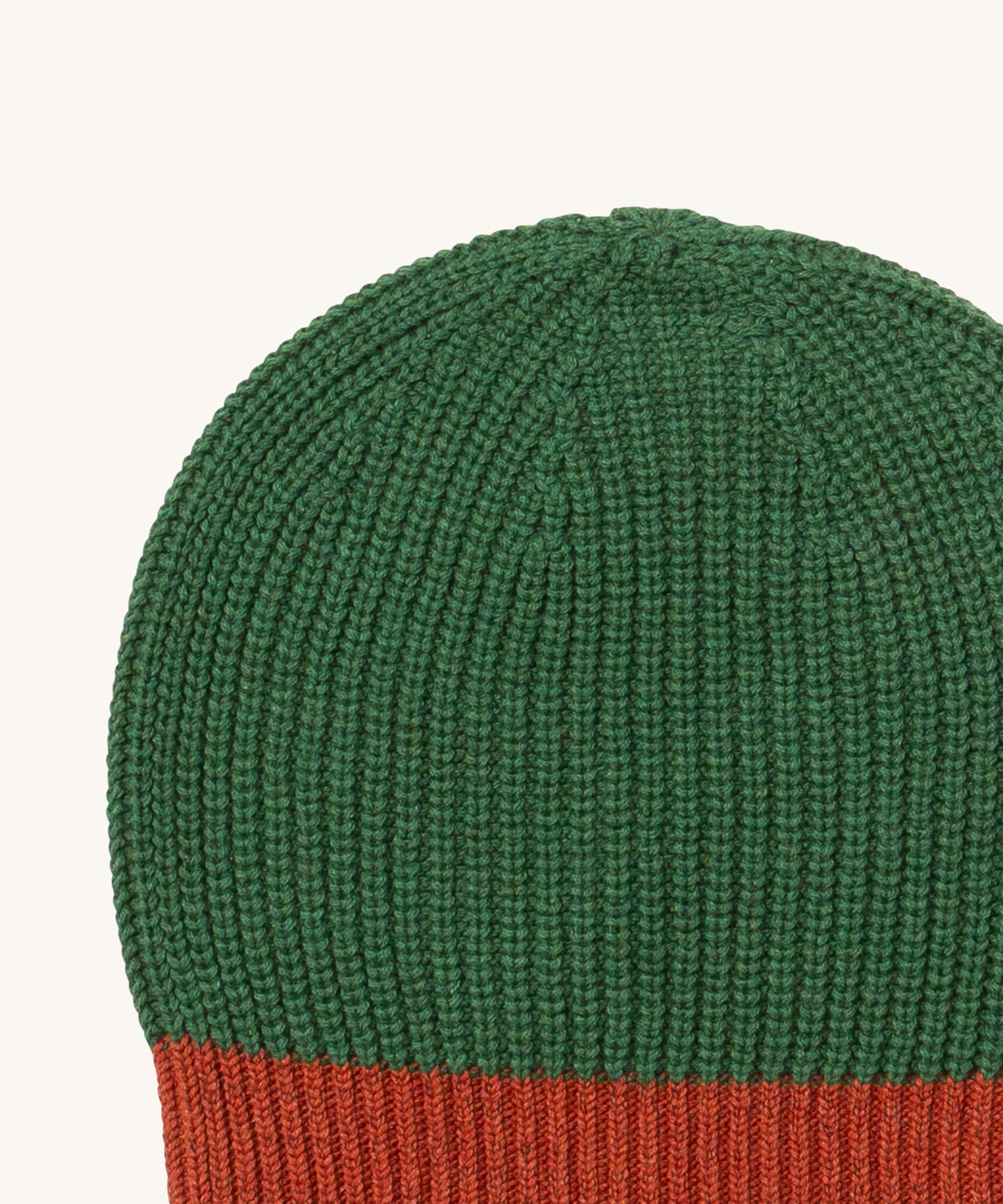 A close up of the Little Green Radicals knitted beanie in chive. Showing the thick green knit detail on organic cotton fabric.