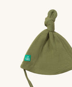 A close up of the Little Green Radicals chive waffle tie hat showing the knot detail  on green organic cotton fabric