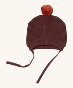 Little Green Radicals chocolate knitted beanie. A brown knitted GOTS organic cotton beanie style hat Features matching brown ties for a secure fit and a light brown pom pom