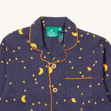 A close up of the Little Green Radicals classic pyjama top from the dark night classic set. showing the yellow trim detail around the collar and pocket. Showing a close up of the starry night print detail and button fasteners on navy organic cotton fabric