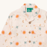A close up of the Little Green Radicals classic pyjama top from the moon and sun set showing the collar and pocket detail on with the button fasteners running down the middle of the light pink organic cotton top