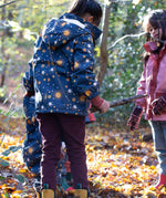 A child playing in the woods and wearing the chocolate comfy trousers. A corduroy style trouser made from GOTS organic cotton fabric.