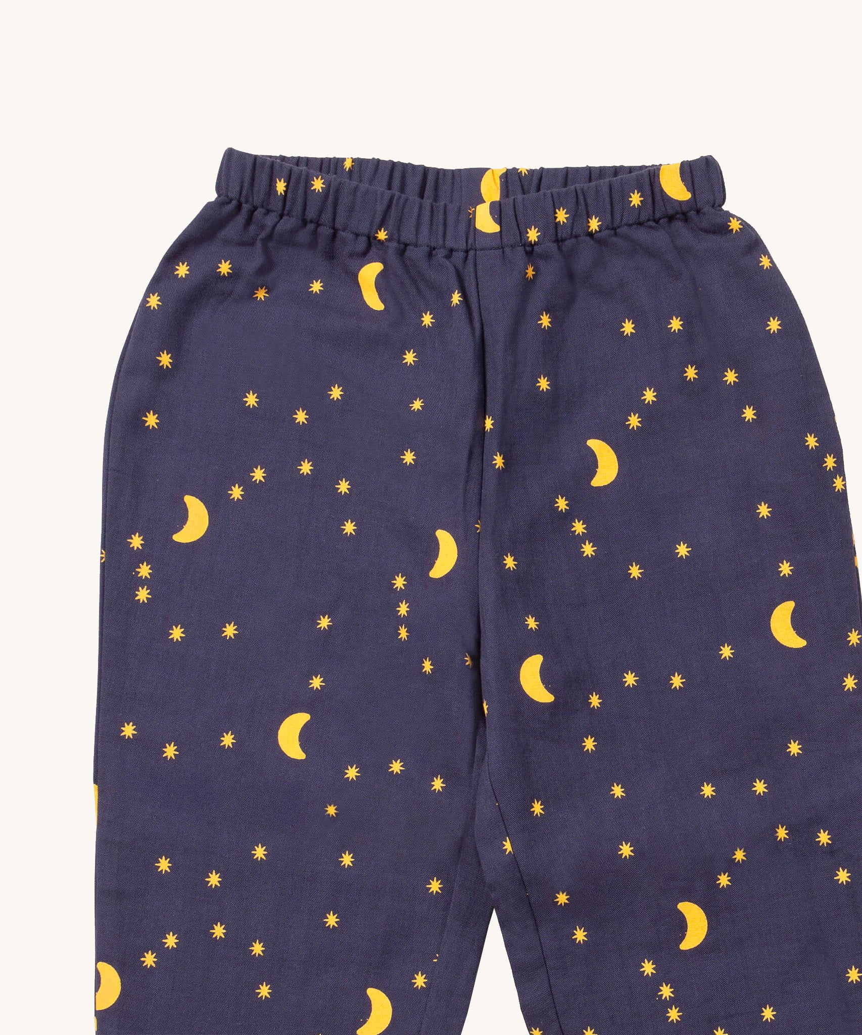 A close up of the Little Green Radicals classic pyjama bottoms from the dark night classic set. Showing the starry night print detail on navy organic cotton fabric.