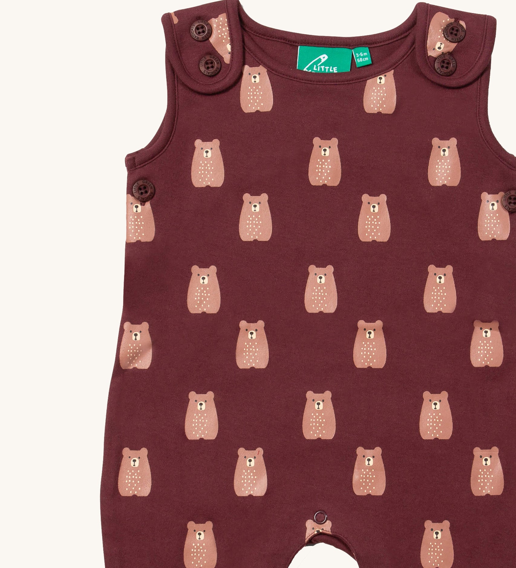 A close up of the Little Green Radicals everyday dungarees in brown bears showing the button fastener detail on the shoulder straps and brown bear print on dark maroon organic cotton fabric.