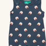 A close up of the Little Green Radicals everyday dungarees in sheep showing the button fastener detail on the shoulder straps and sheep print on navy organic cotton fabric.