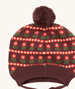 A close up of the Little Green Radicals flower collecting knitted beanie hat showing the retro red flower design detail and brown pom pom on organic cotton fabric.