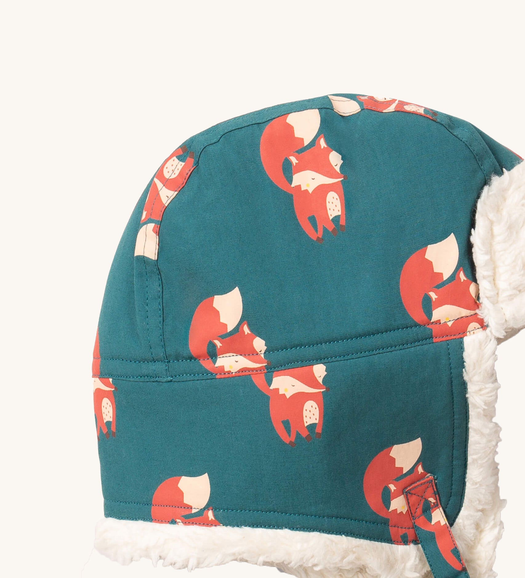 A close up of the Little Green Radials sherpa fleece cosy hat in foxes. Showing the cute fox print detail and stitching detail on turquoise organic cotton fabric