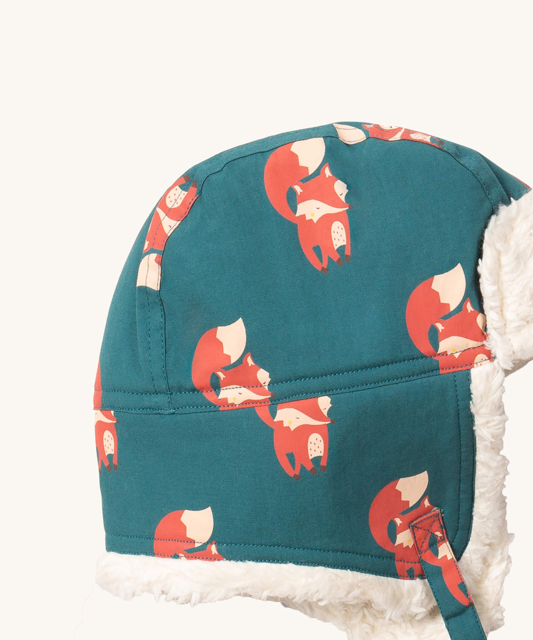 A close up of the Little Green Radials sherpa fleece cosy hat in foxes. Showing the cute fox print detail and stitching detail on turquoise organic cotton fabric