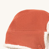 A close up of the Little Green Radicals sherpa fleece cosy hat in ginger. Showing the corduroy detail  on dark orange organic cotton fabric