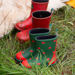 A pair of Little Green Radicals kid wellington boots next to a pair of the red wellies. Natural rubber waterproof wellies. Features a red toe cap, gripped sole and pull-on tab for easy fitting