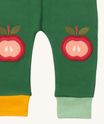 A close up of the Little Green Radicals kneepatch joggers in red apples showing the yellow and light green cuff detail organic cotton fabric 