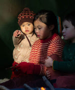 A child wearing the Little Green Radicals knitted cardigan in puddle ducks outside under a shelter 