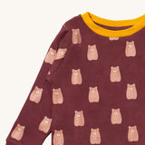 A close up of the Little Green Radicals brown bear pyjama set showing the elasticated cuff detail and the  yellow collar trim with a  close up of the brown bear detail on organic cotton fabric.