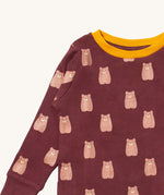 A close up of the Little Green Radicals brown bear pyjama set showing the elasticated cuff detail and the  yellow collar trim with a  close up of the brown bear detail on organic cotton fabric.