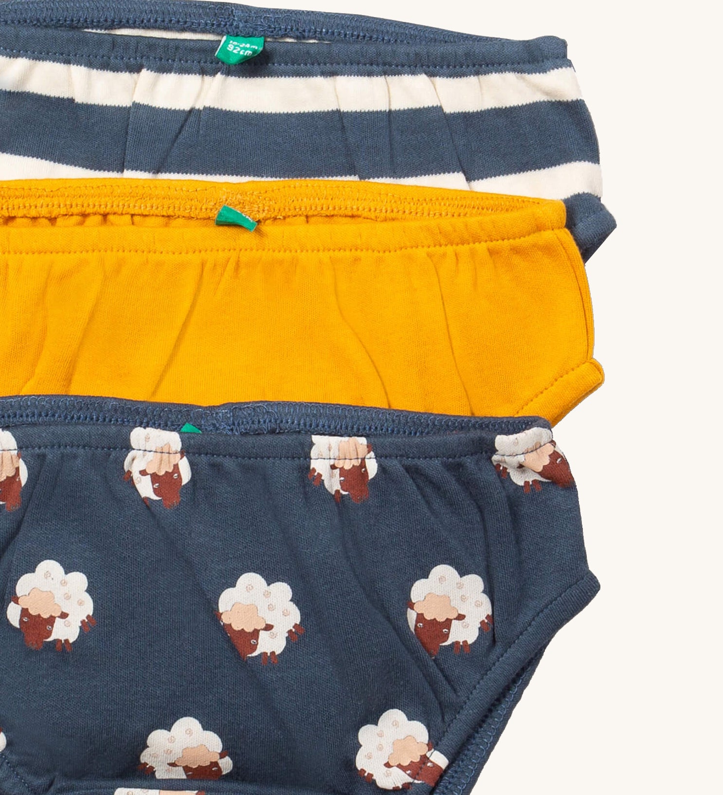 A close up of the Little Green Radicals sleeping sheep underwear. Showing the trim detail and and a close up of each print and colour on organic cotton fabric.