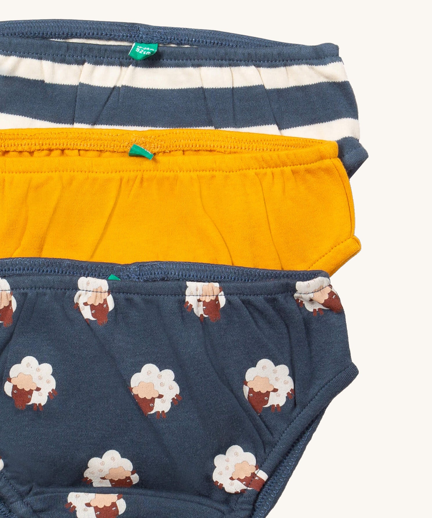A close up of the Little Green Radicals sleeping sheep underwear. Showing the trim detail and and a close up of each print and colour on organic cotton fabric.