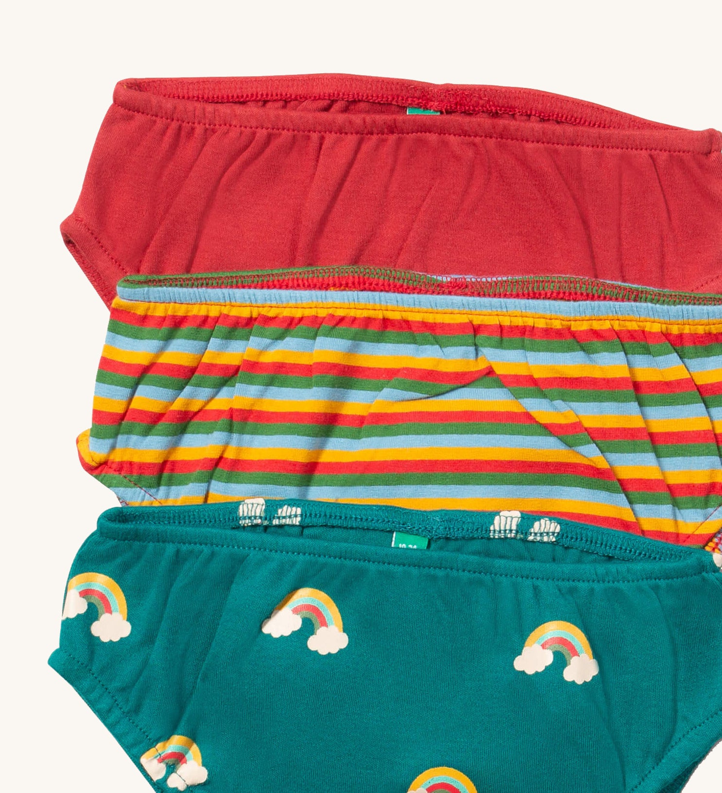 A close up of the Little Green Radicals turquoise rainbows underwear. Showing the trim detail and and a close up of each print and colour on organic cotton fabric.