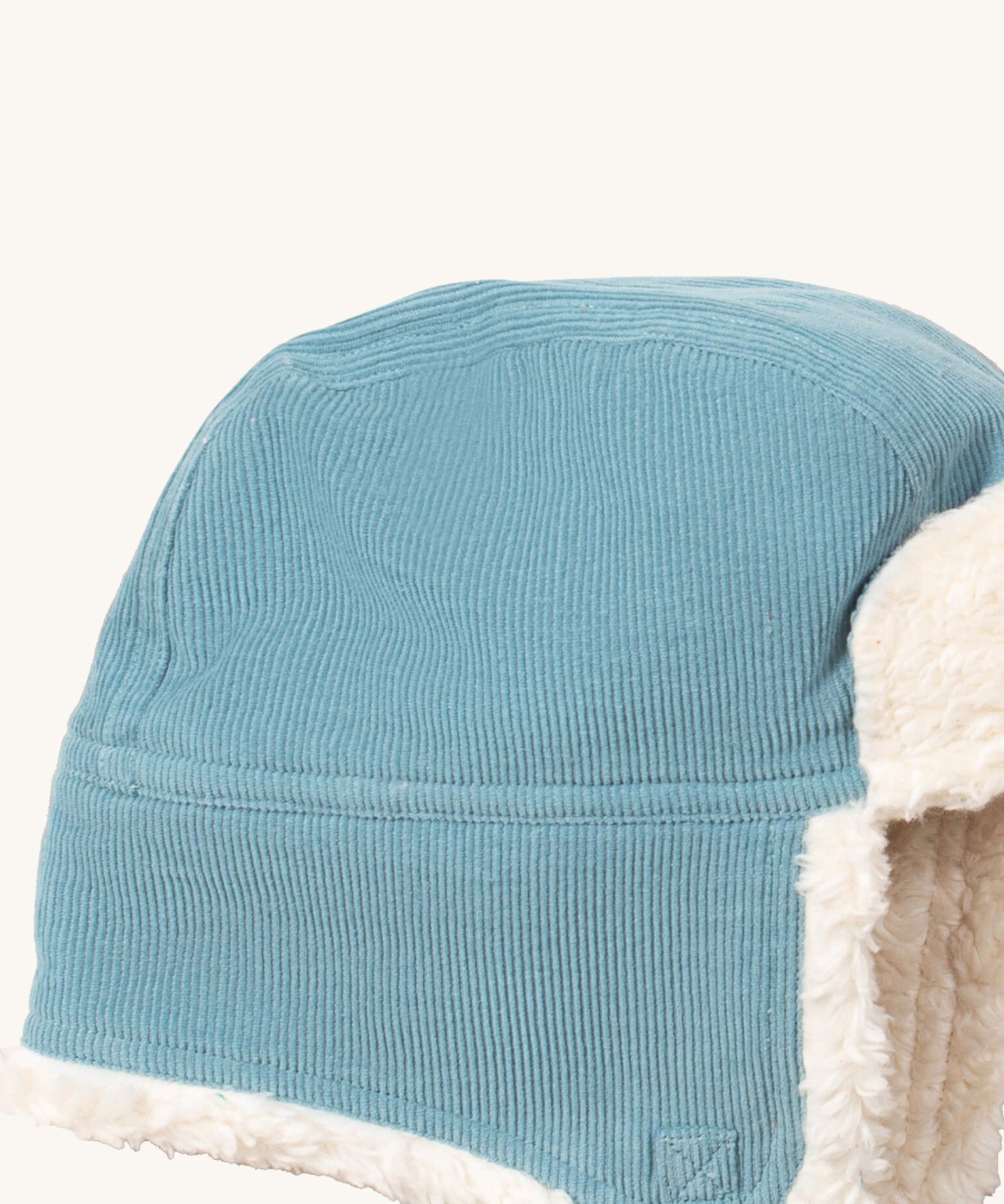 A close up of the Little Green Radicals sherpa fleece cosy hat in pale blue. Showing the corduroy detail on blue orange organic cotton fabric