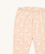 A close up of the Little Green Radicals puddle ducks pyjama bottom showing the elasticated waist band detail with a close up of the white puddle duck print detail on organic cotton fabric.