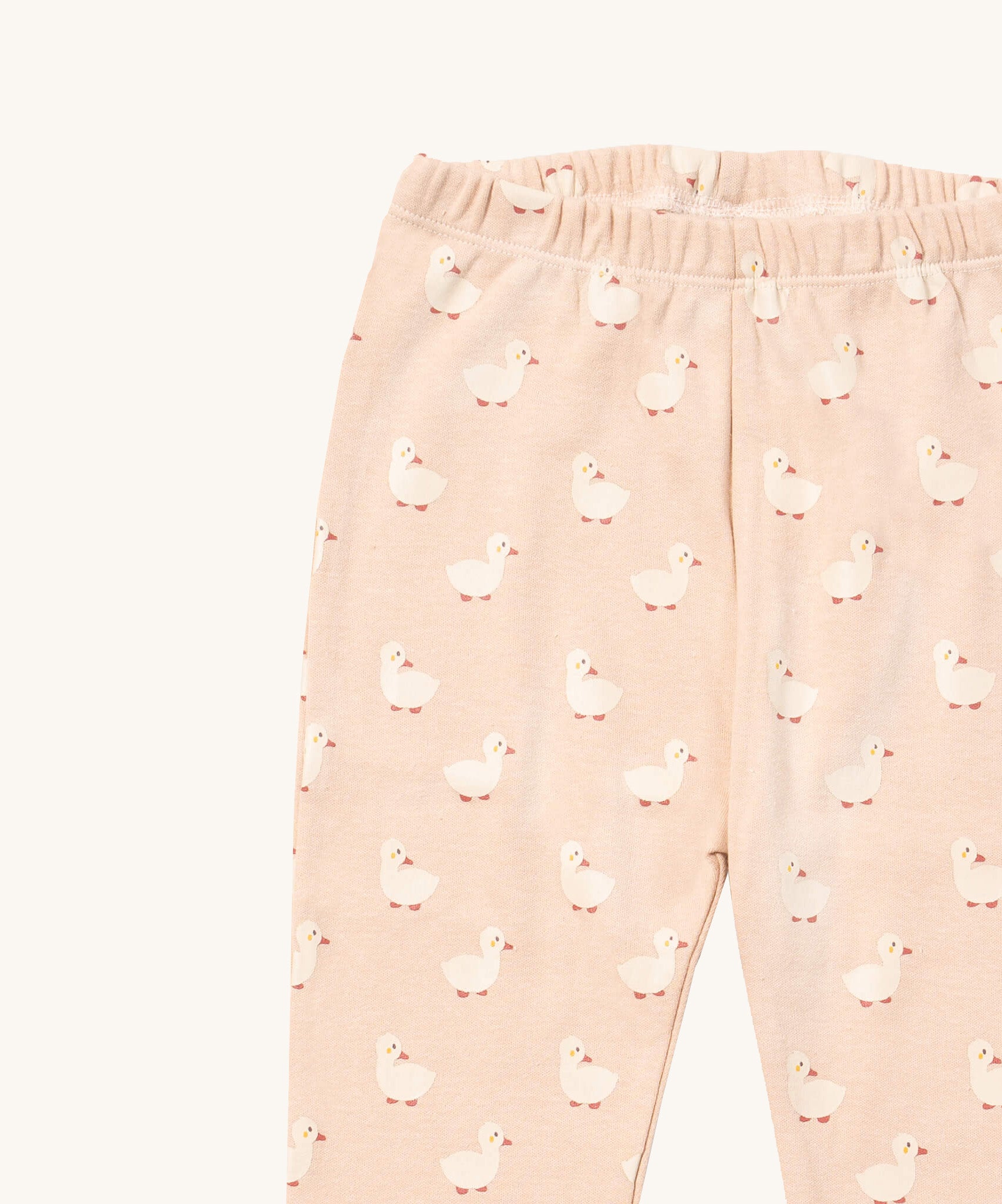 A close up of the Little Green Radicals puddle ducks pyjama bottom showing the elasticated waist band detail with a close up of the white puddle duck print detail on organic cotton fabric.