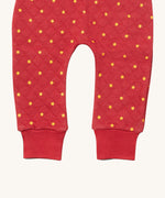 A close up of the Little Green Radicals red star quilted joggers. Showing the quilted stitch and elasticated leg cuff detail on red organic cotton fabric.