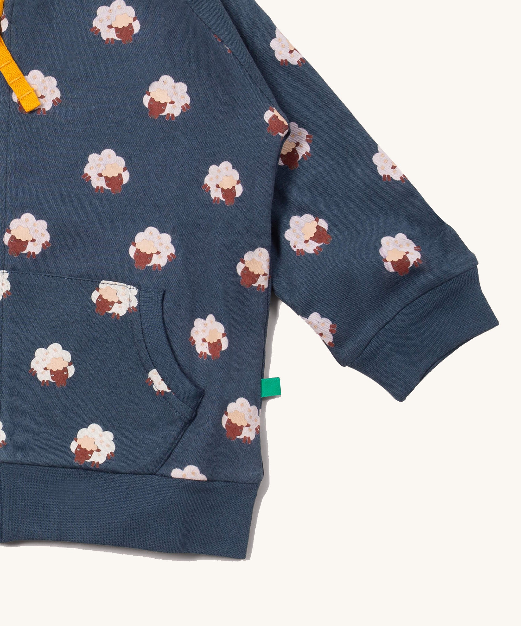 A close up of the Little Green Radicals reversible easy rider jacket in sleeping sheep. Showing the pouch pocket detail and a close up of the sheep print on navy GOTS organic cotton fabric