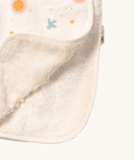 A close up of the sherpa fleece style inner from the sun and moon Little Green Radicals hooded blanket. Showing the fleece detail on white organic cotton fabric.