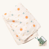 A folded Little Green Radicals sun and moon sherpa hooded blanket. A GOTS organic cotton white blanket with cute prints of birds flying around stars, the moon and the sun.