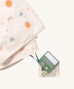 A close up of the  folded Little Green Radicals sun and moon sherpa hooded blanket. Showing the white trim detail around the edge of the blanket
